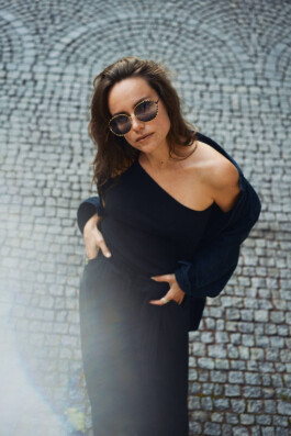 elegant-woman-wearing-baggy-black-pants-standing-on-cobblestones 