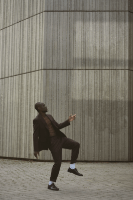 black-male-dancer-white-socks-suit-modern-dance-brutalist-architecture-grey-suit 