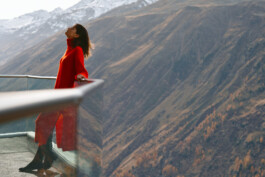 woman-red-dress-leaning-back-eyes-closed-peaceful-contemplative-moment-alpine-environment 
