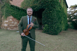 cool-color-matched-portrait-green-menswear-suit-green-ivy-background-holding-violin-classical-musician-portrait 